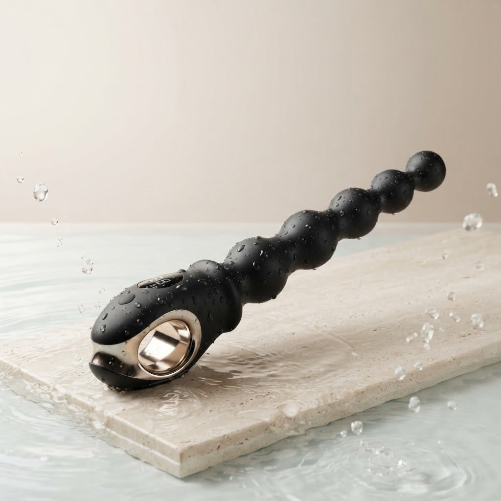 Velora beaded vibrator with water droplets on a stone surface